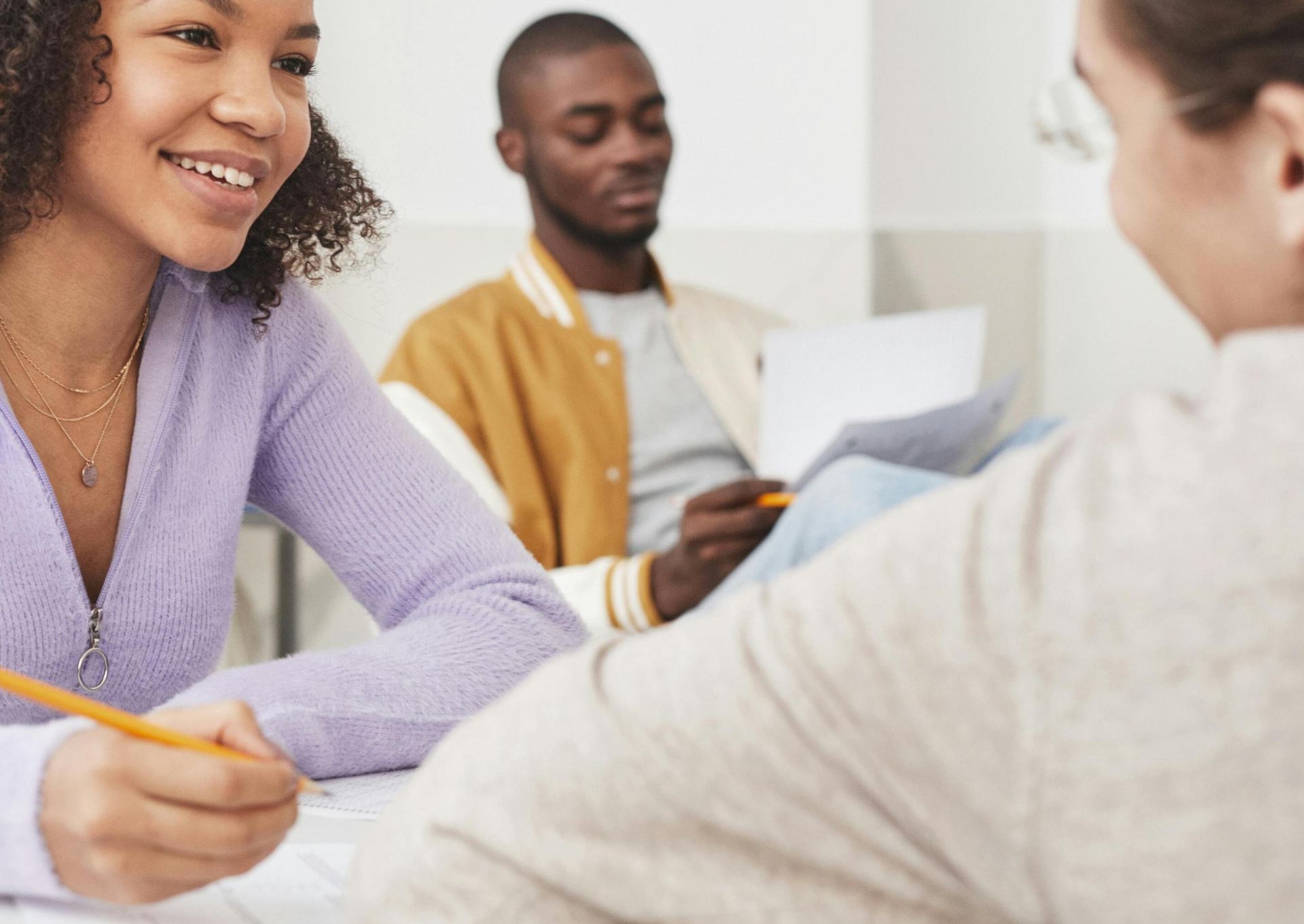 Group of diverse students interacting and studying in a classroom environment.