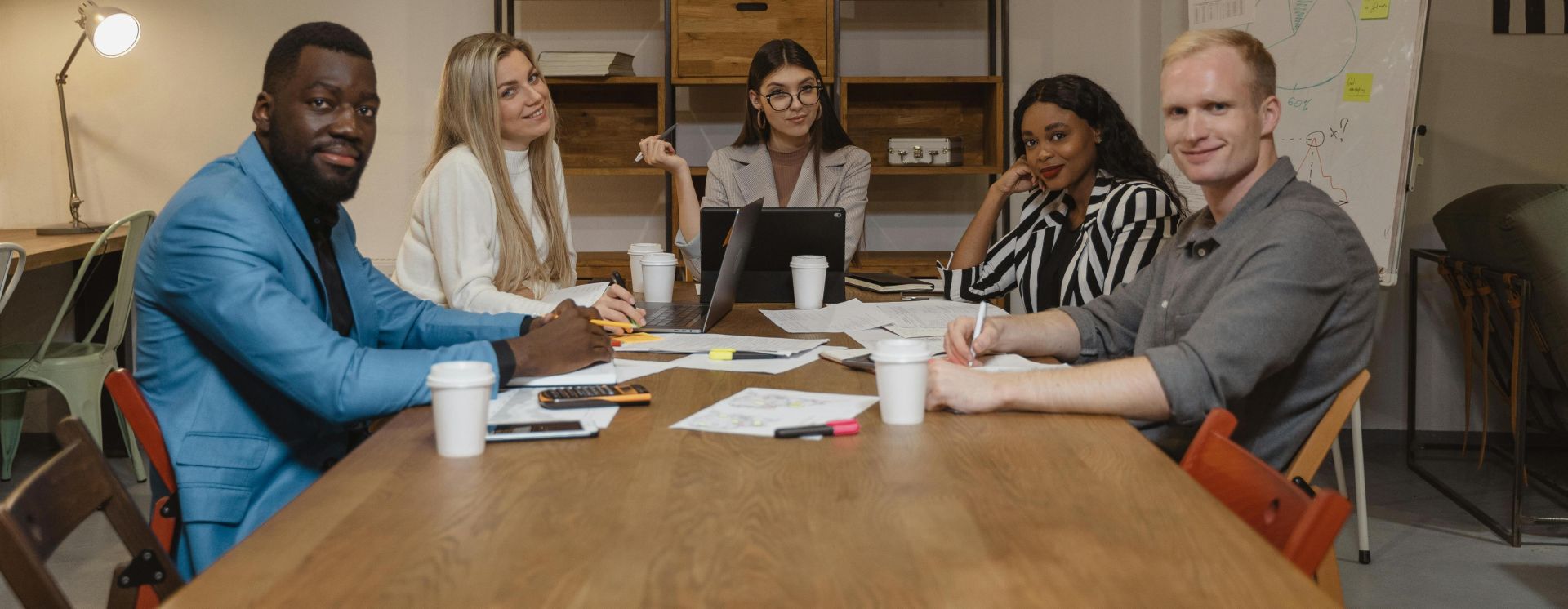 A diverse group of professionals engaged in a productive meeting in a contemporary office environment.
